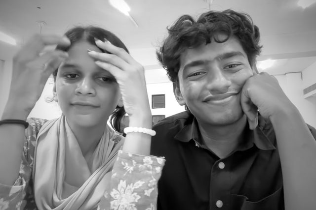 A black-and-white selfie with a hand resting on a forehead.