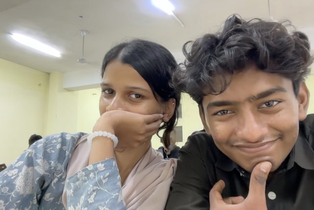 Two friends posing with their hands beneath their faces.
