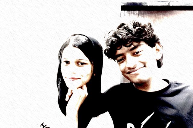 A high-contrast photo-booth selfie of two friends.