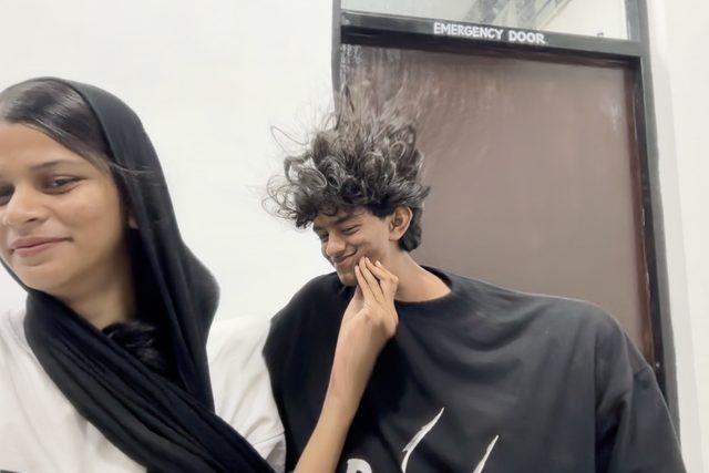 A candid indoor moment with two friends looking away.