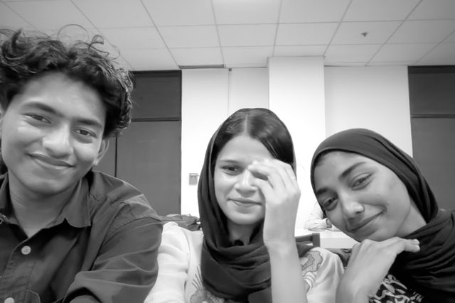 A black-and-white group selfie with three people.