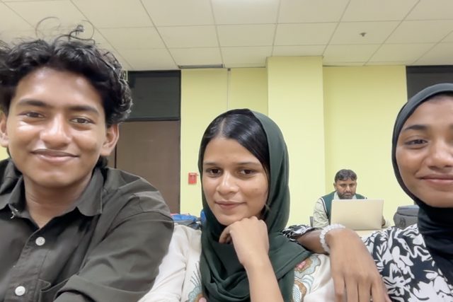 Three people sitting close together for a selfie.